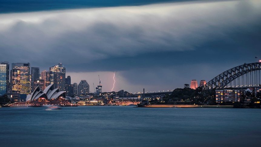 sydney harbour underneath dark clouds and lightning