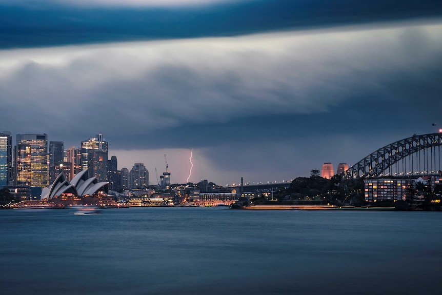 sydney harbour underneath dark clouds and lightning