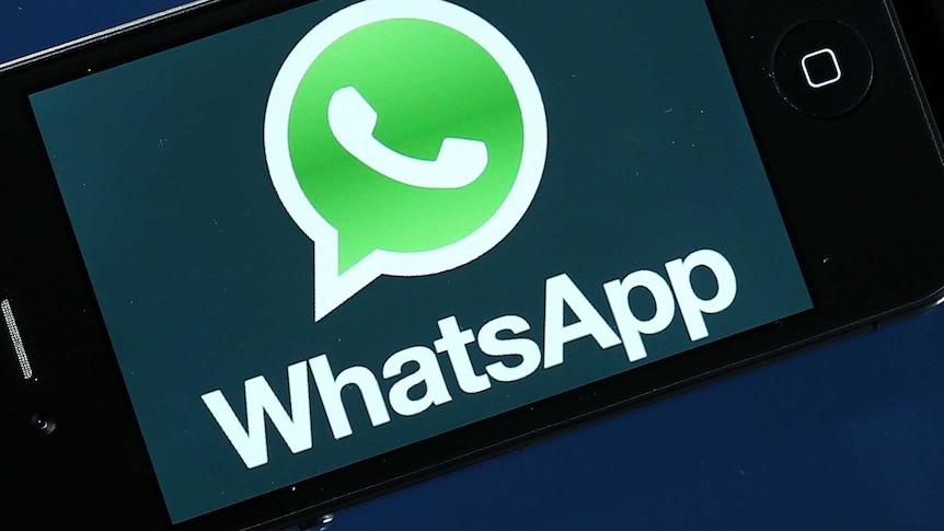 The WhatsApp logo is seen on the screen of a smartphone