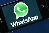 The WhatsApp logo is seen on the screen of a smartphone