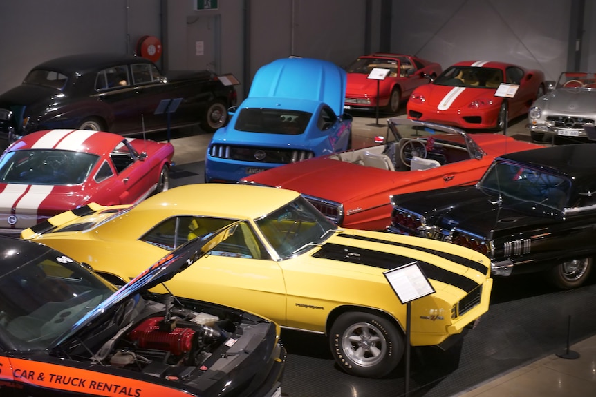 a photo of a range of old cars in a car museum.