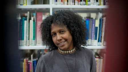 Sue Mcpherson standing in a library.