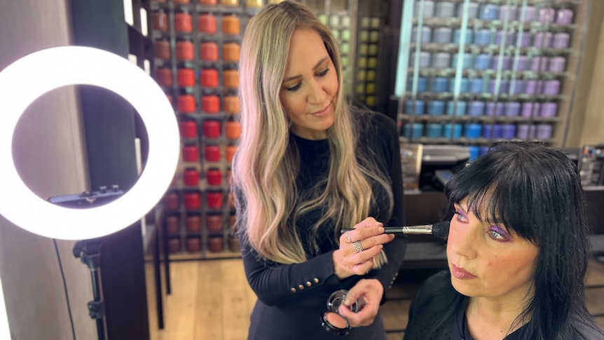 A woman applying make up to another woman