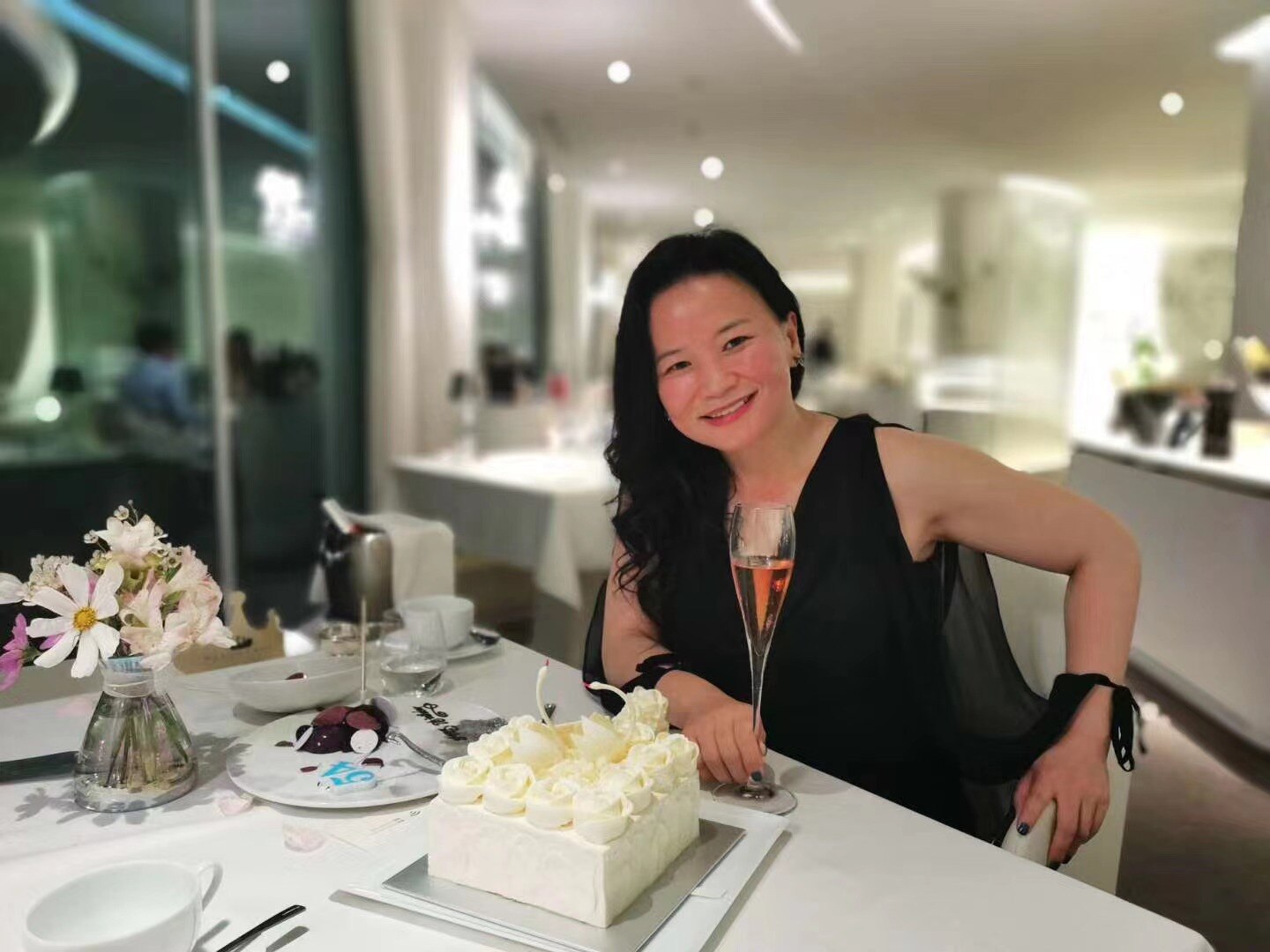 Cheng Lei sitting at a table with a cake.