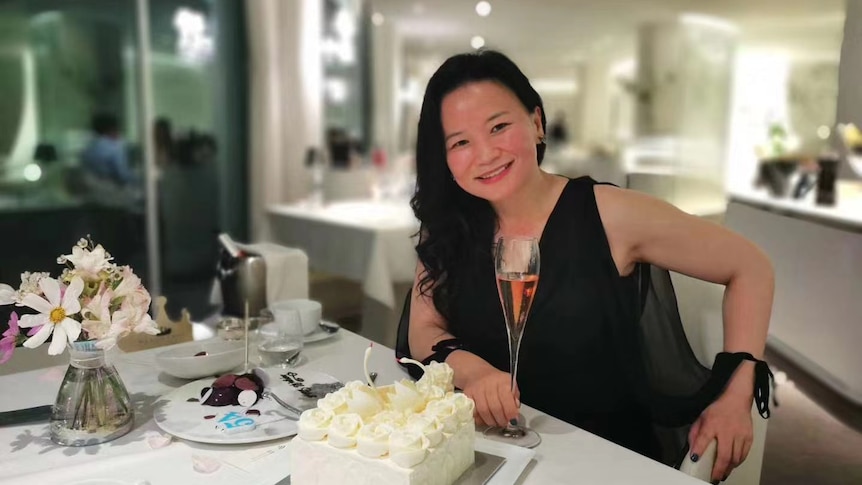 Cheng Lei sitting at a table with a cake.