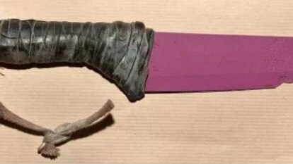 A pink-bladed knife with leather wrapped around the handle.