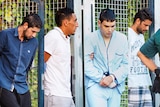 A composite image of four handcuffed men outside court.