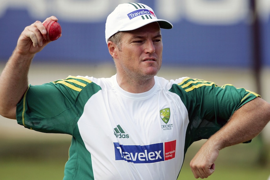 Stuart MacGill, wearing Australian training gear, prepares to bowl