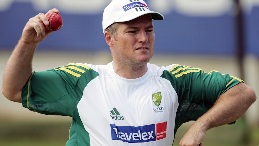 Stuart MacGill, wearing Australian training gear, prepares to bowl