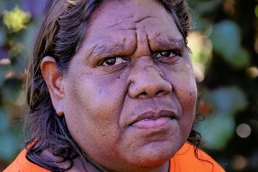 A close up photo of Indigenous woman Annabell Landy, who is wearing a fluoro orange top.