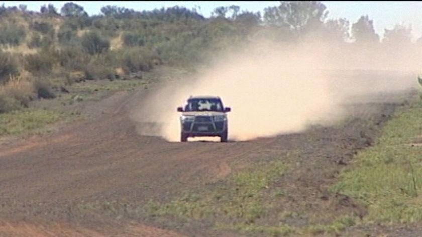 Country road.... car on gravel road raises dust