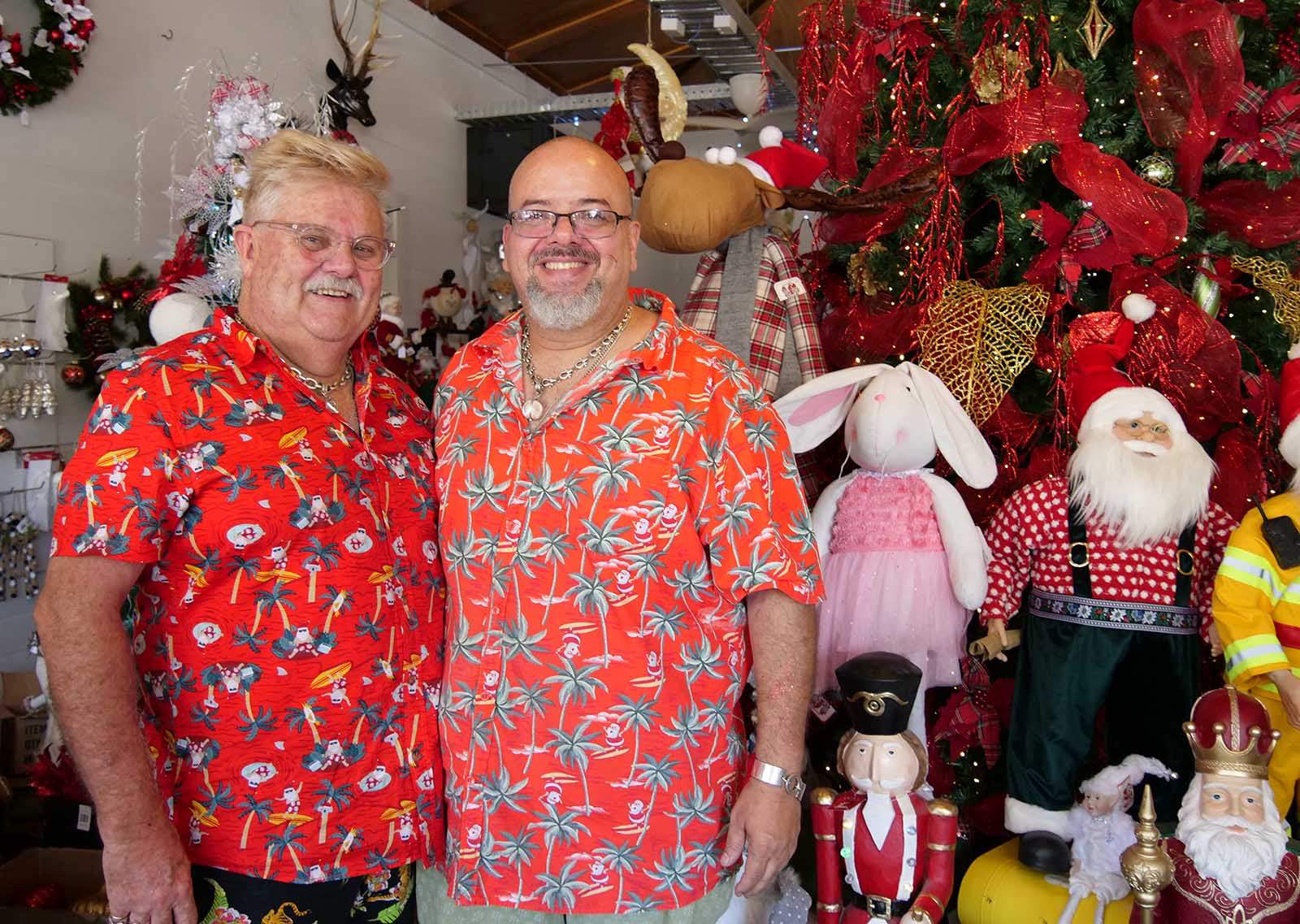 Two men in red Hawaiian shirts standing in a Christmas shop