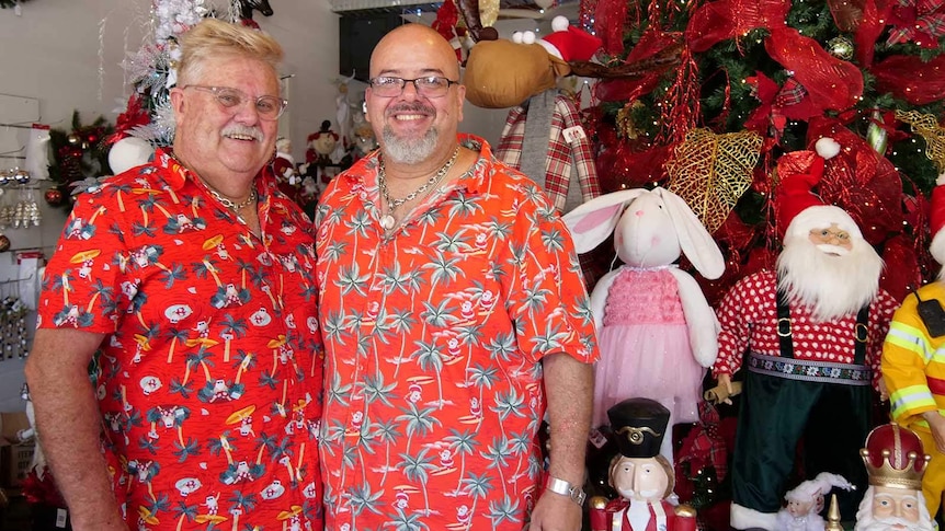 Two men in red Hawaiian shirts standing in a Christmas shop