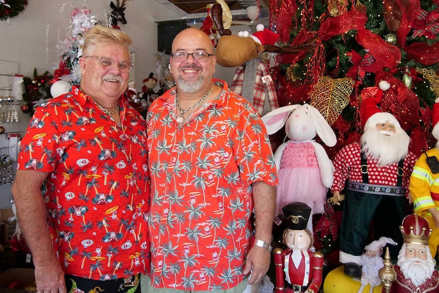 Two men in red Hawaiian shirts standing in a Christmas shop