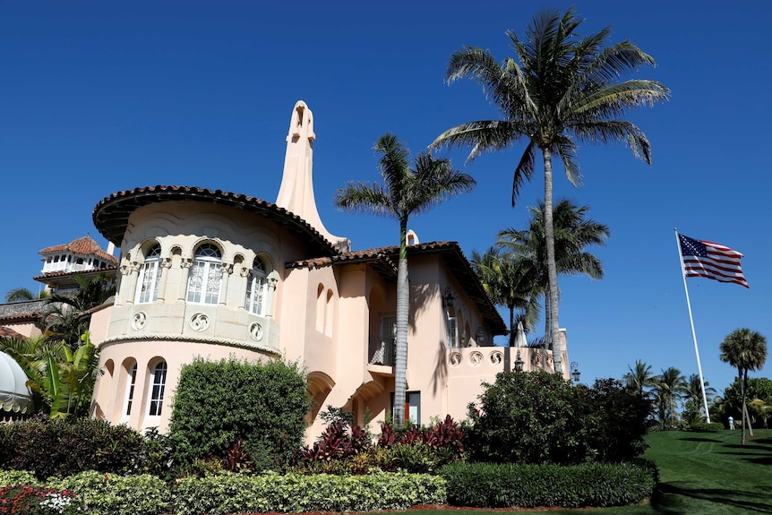 An outside view of Donald Trump's resort with pinkish walls and a hacienda look.