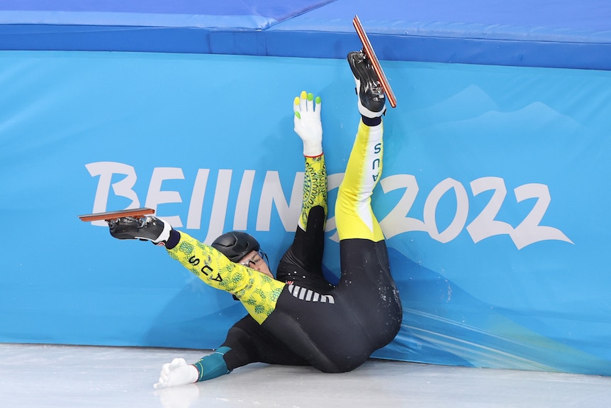Man on back against wall on ice with legs in air