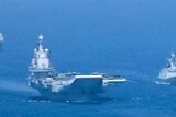 一艘航空母舰在海军护卫舰和潜艇的陪同下在南中国海航行。