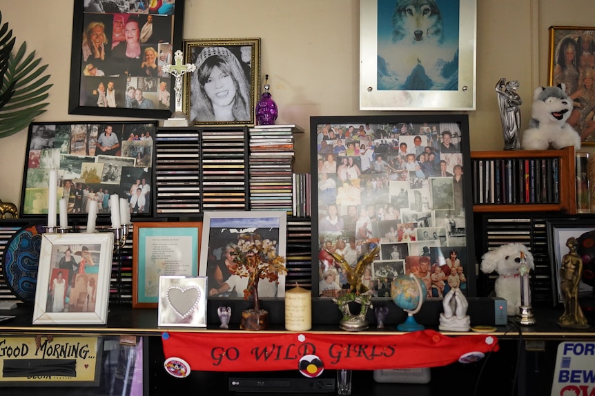 A shelf stacked with photos and CDs.