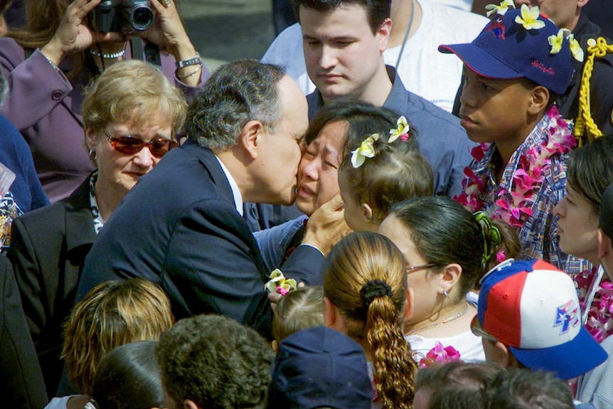 Rudy Giuliani kisses the cheek of a sobbing woman