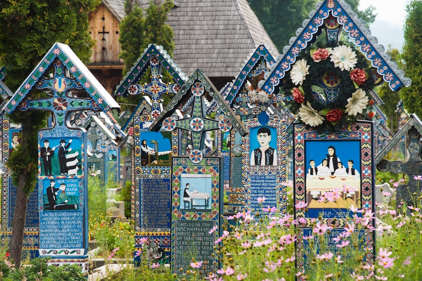 A row of bright blue wooden headstones.