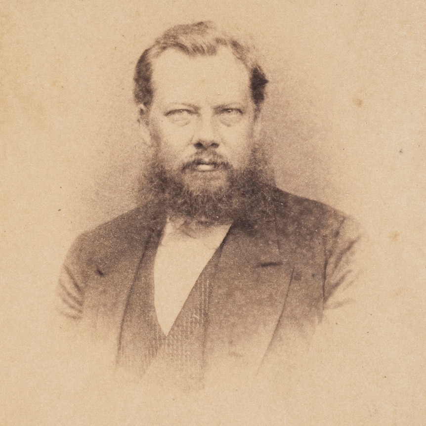 A sepia photo portrait of a man with a bushy beard