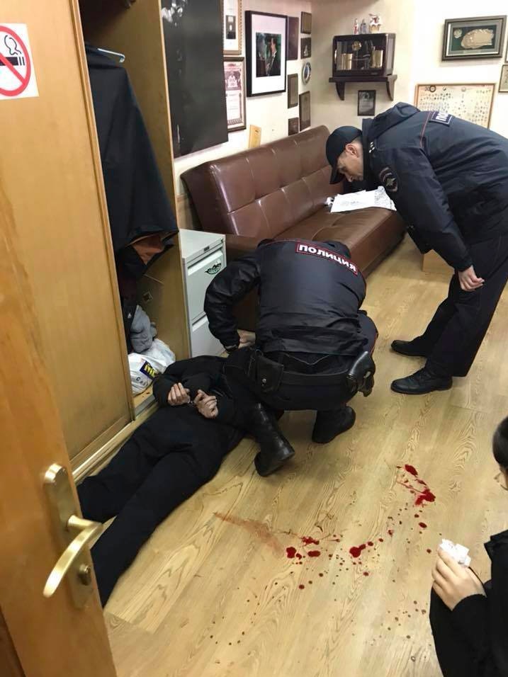 Police officers detain an unidentified man who reportedly stabbed journalist Tatyana Felgenhauer.