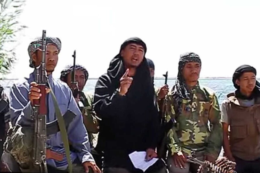 A screenshot of Indonesian jihadists talking with guns