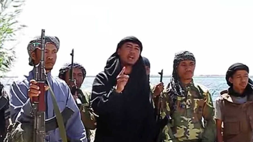 A screenshot of Indonesian jihadists talking with guns
