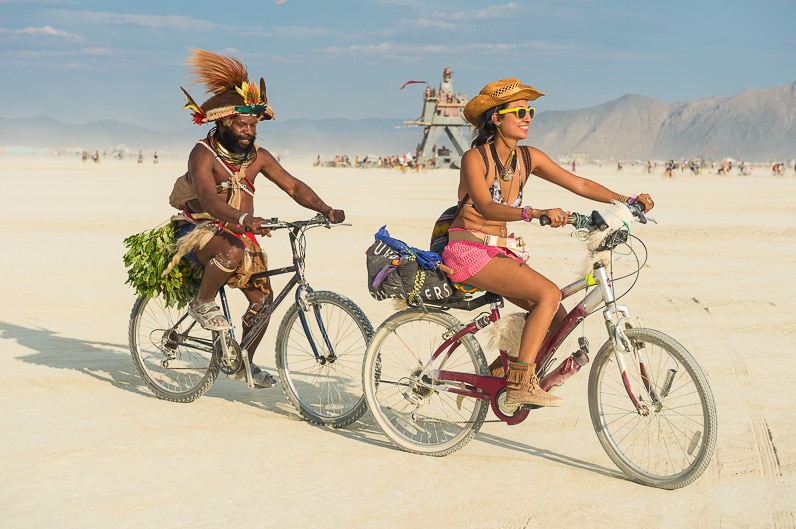PNG Highlands chief Mundiya Kepanga rides a bike with a woman at Burning Man festival, Black Rock City, Nevada.