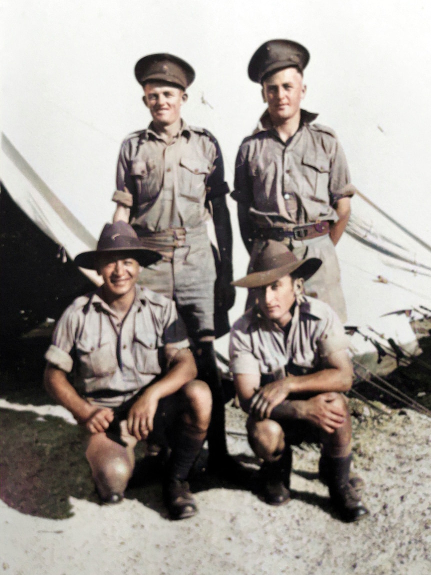 Hand coloured photo - Four Australian soldiers in front of a tent in sunshine