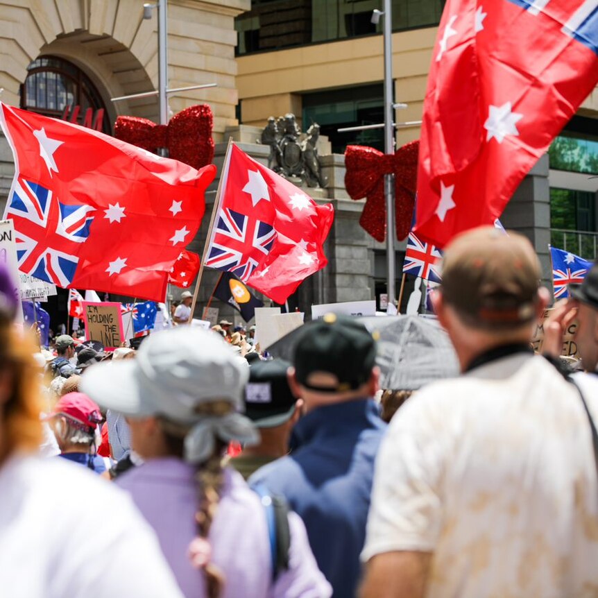 A wide shot of a crowd in Forrest Place with red Australian flags.