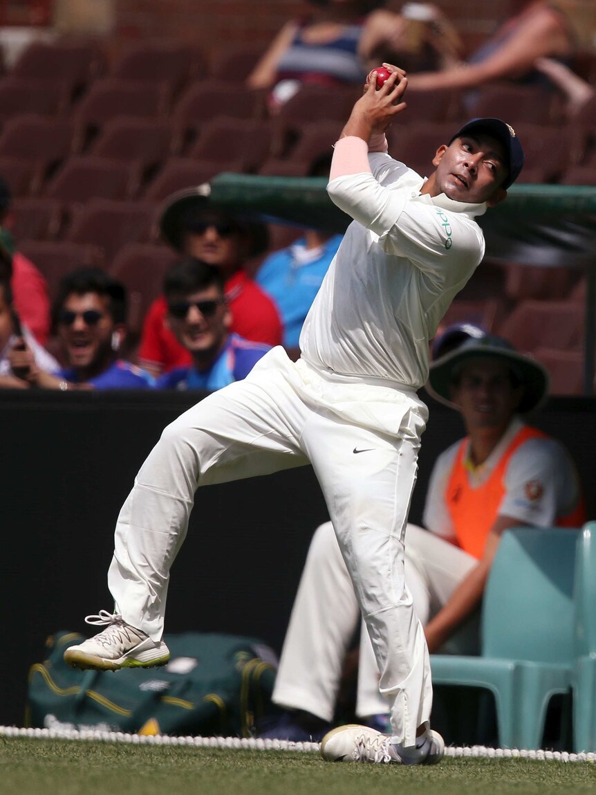 India's Prithvi Shaw rolls his ankle as he attempts a catch at the SCG on November 30, 2018.