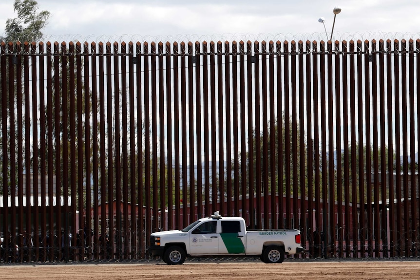 A U.S. Customs and Border Protection vehicle sits near the Mexico-US border wall in California.