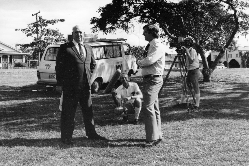 Mayor Rockhampton Rex Pilbeam, being interviewed by Doug Murphy, Joe Mooney, Bruce Black. ABC news van in the background. BW pic