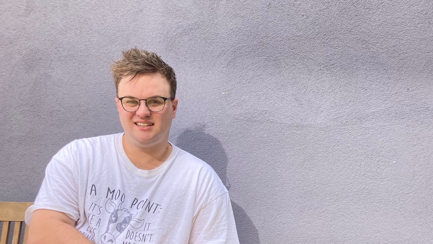 A man on a bench in front of a wall