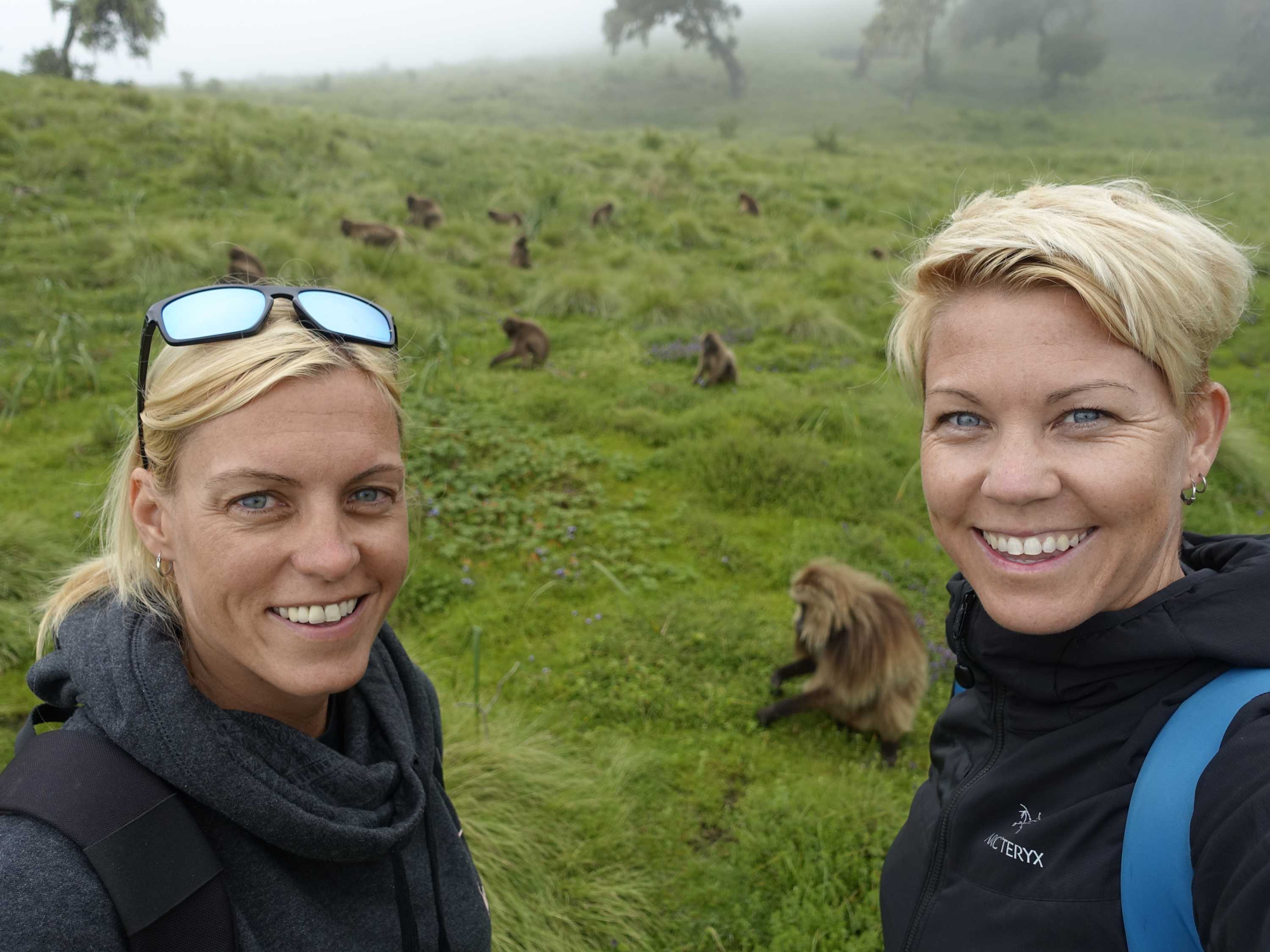 Martina and Rachel take a selfie photo in front of monkeys in Ethiopia