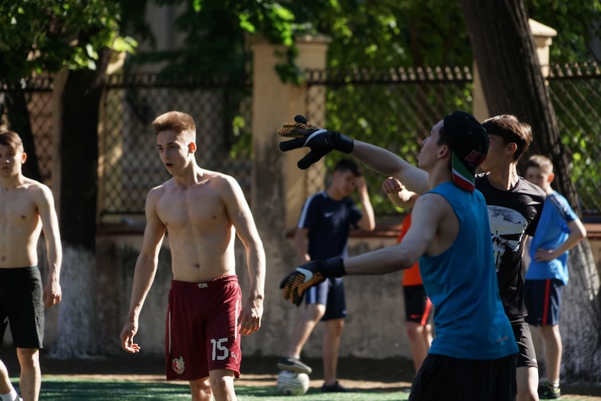 Teenage boys play football.