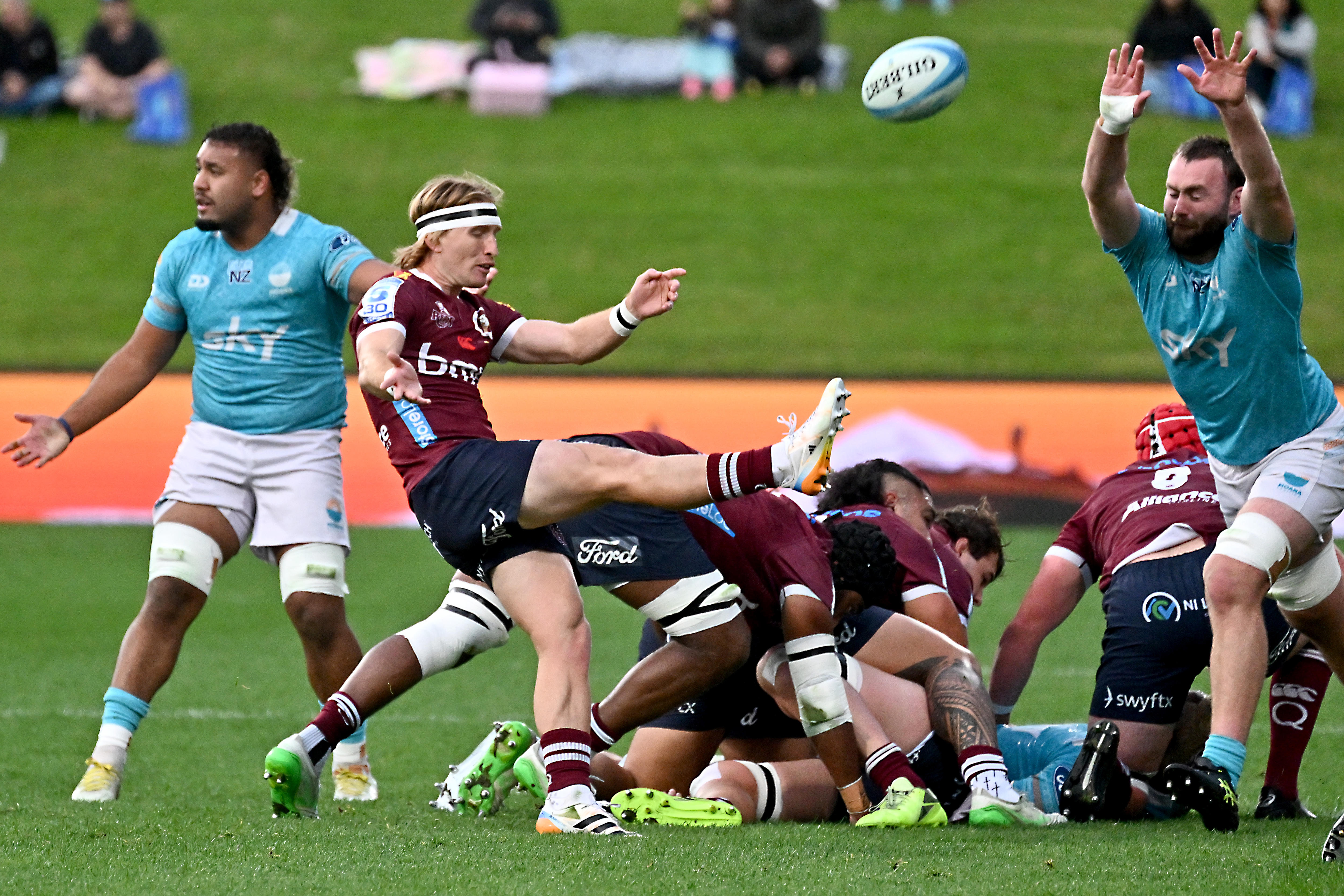 Tate McDermott does a box kick for the Queensland reds against Moana Pasifika.
