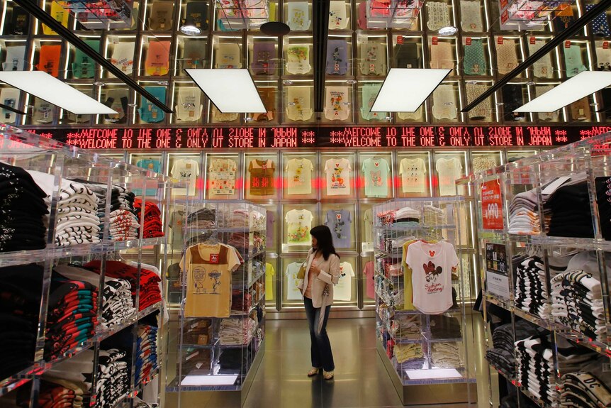 A shopper walks through a Uniqlo clothing store in Tokyo.