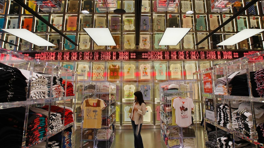 A shopper walks through a Uniqlo clothing store in Tokyo.