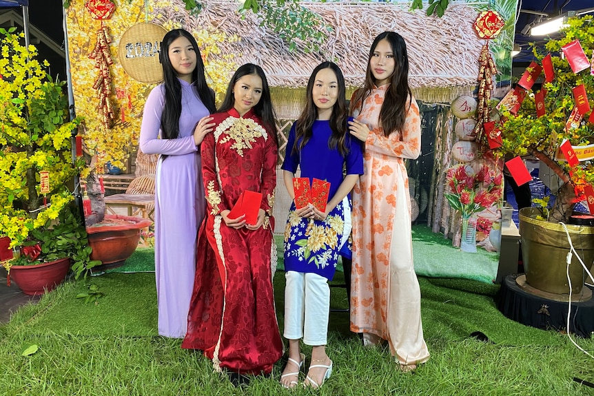 Four women dressed in long tunics and pants