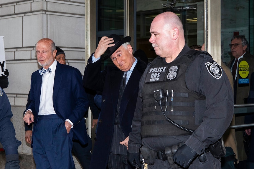 Stone pictured just after he put his hat on as he walks out of court after his sentencing.