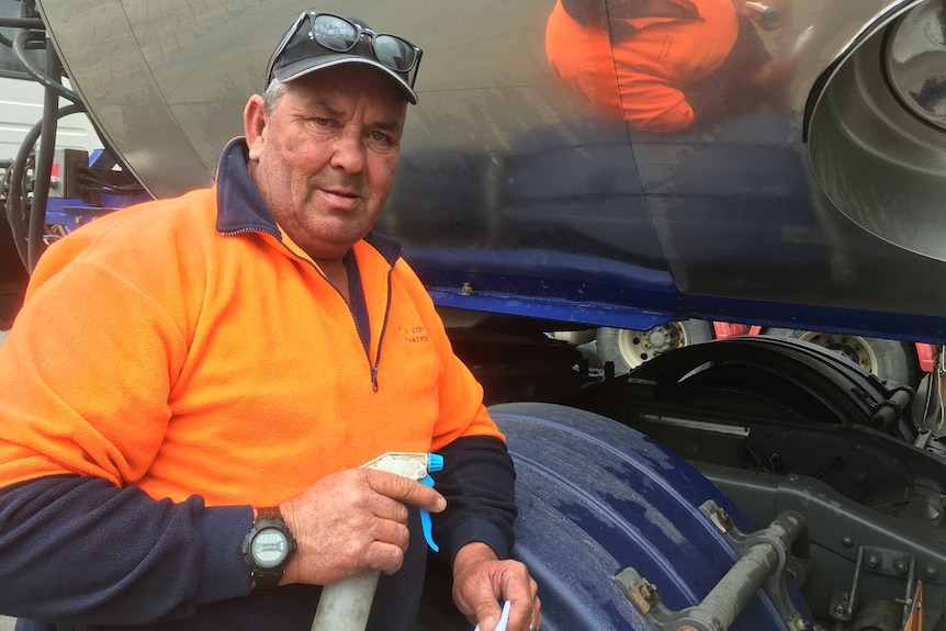 Geoff Riley standing in front of milk tanker