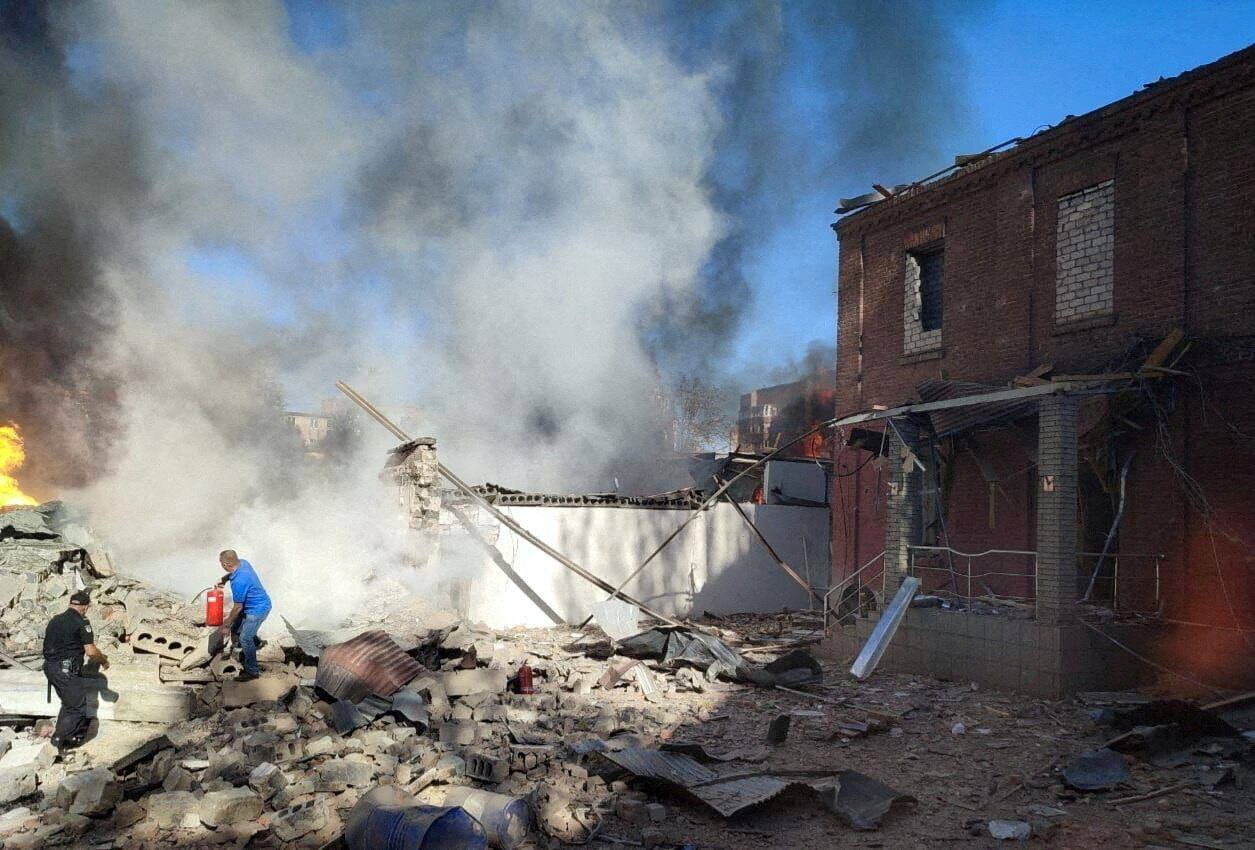 A local man tries to extinguish burning buildings at a site of a Russian missile strike.