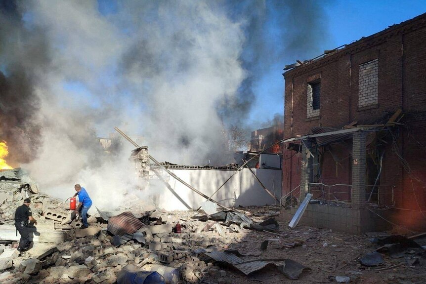 A local man tries to extinguish burning buildings at a site of a Russian missile strike.