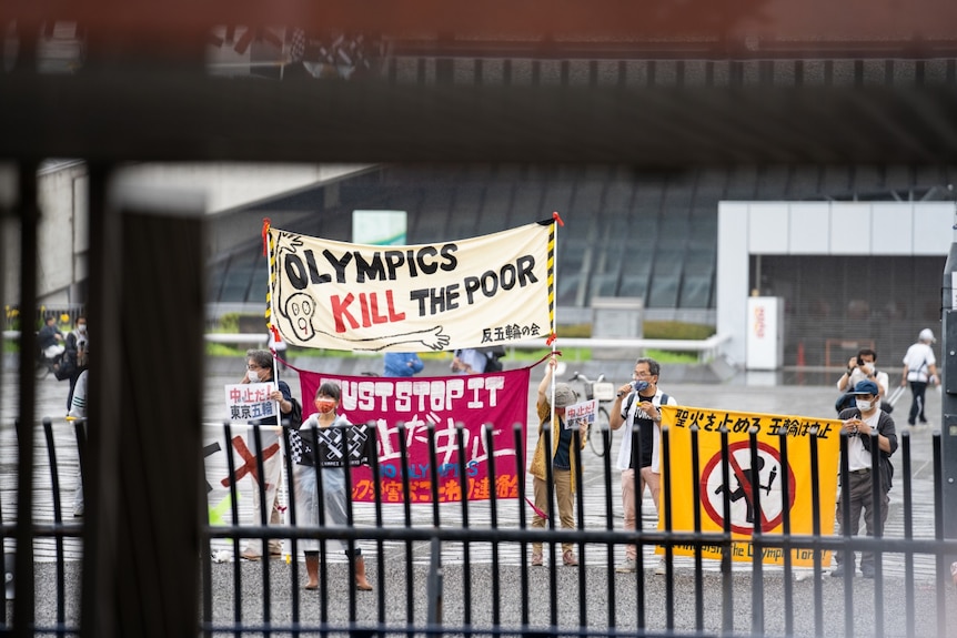 Un grupo de manifestantes sosteniendo un cartel que decía 'Los Juegos Olímpicos matan a los pobres' 