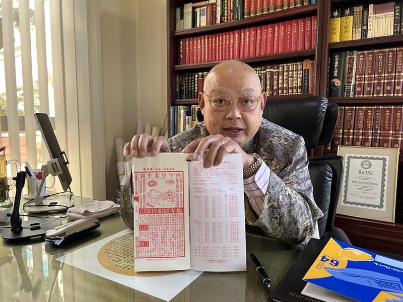     Um homem segura um livro de feng shui.