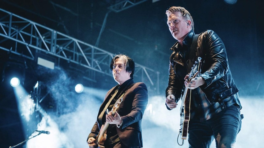 image of josh homme and troy van leeuwinplaying guitar on stage at splendour in the grass