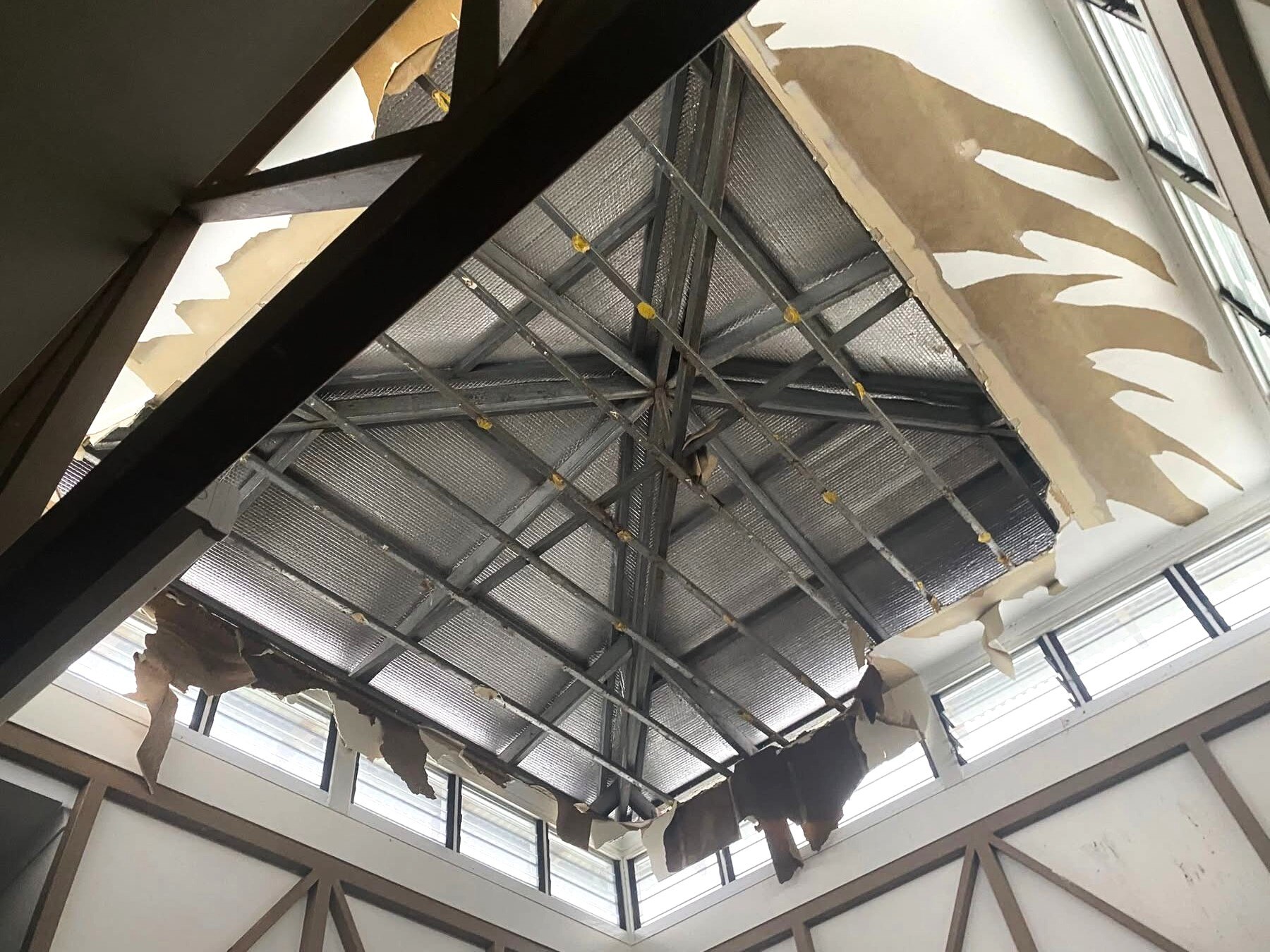 Olhando para o teto/telhado, a tinta está rasgada até o teto e parece marrom por baixo.