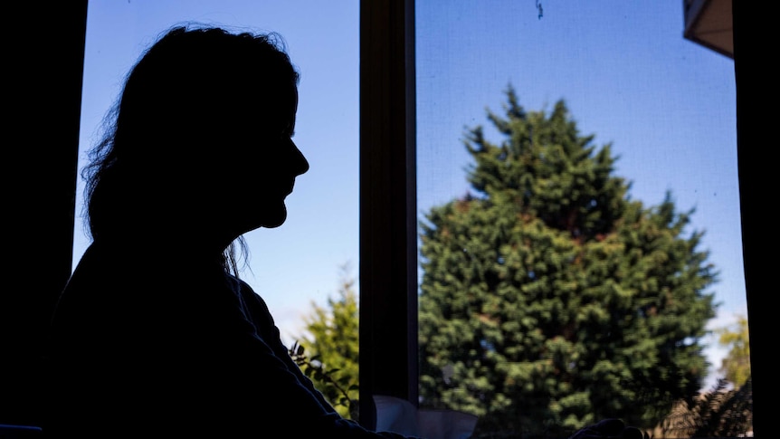 Silhouette of older woman framed in a window